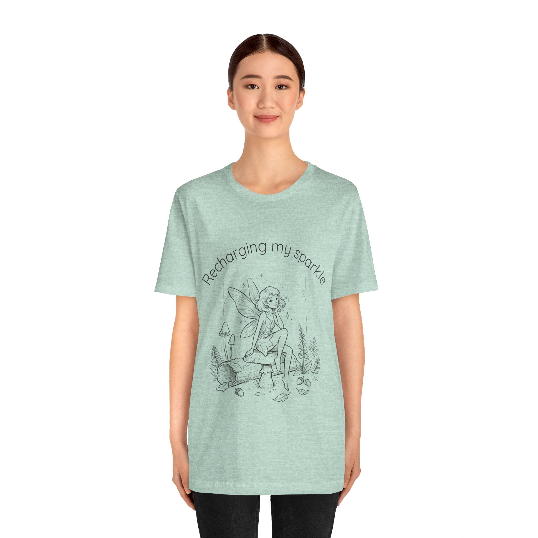 Vintage fairy graphic T-shirt with "Recharging My Sparkle" slogan, featuring colorful fairy illustration on a casual Printify tee.