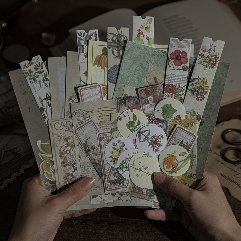Open butterfly, floral, and fairy sticker book by 24 Hour Crafts showing colorful enchanted stickers inside.