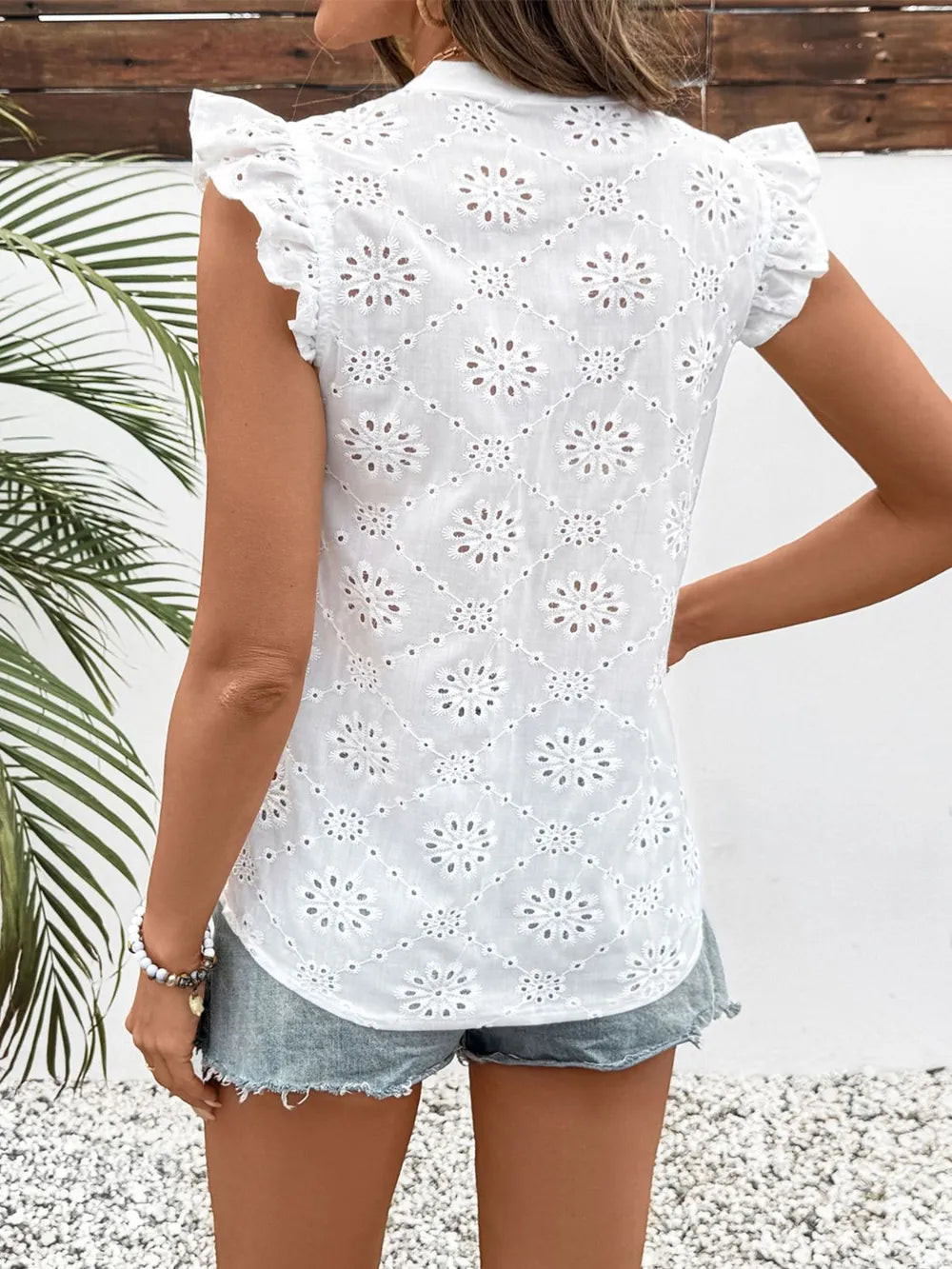 White floral Rosehaven eyelet ruffle cap sleeve blouse shown from the back, featuring delicate eyelet details and charming ruffle accents.