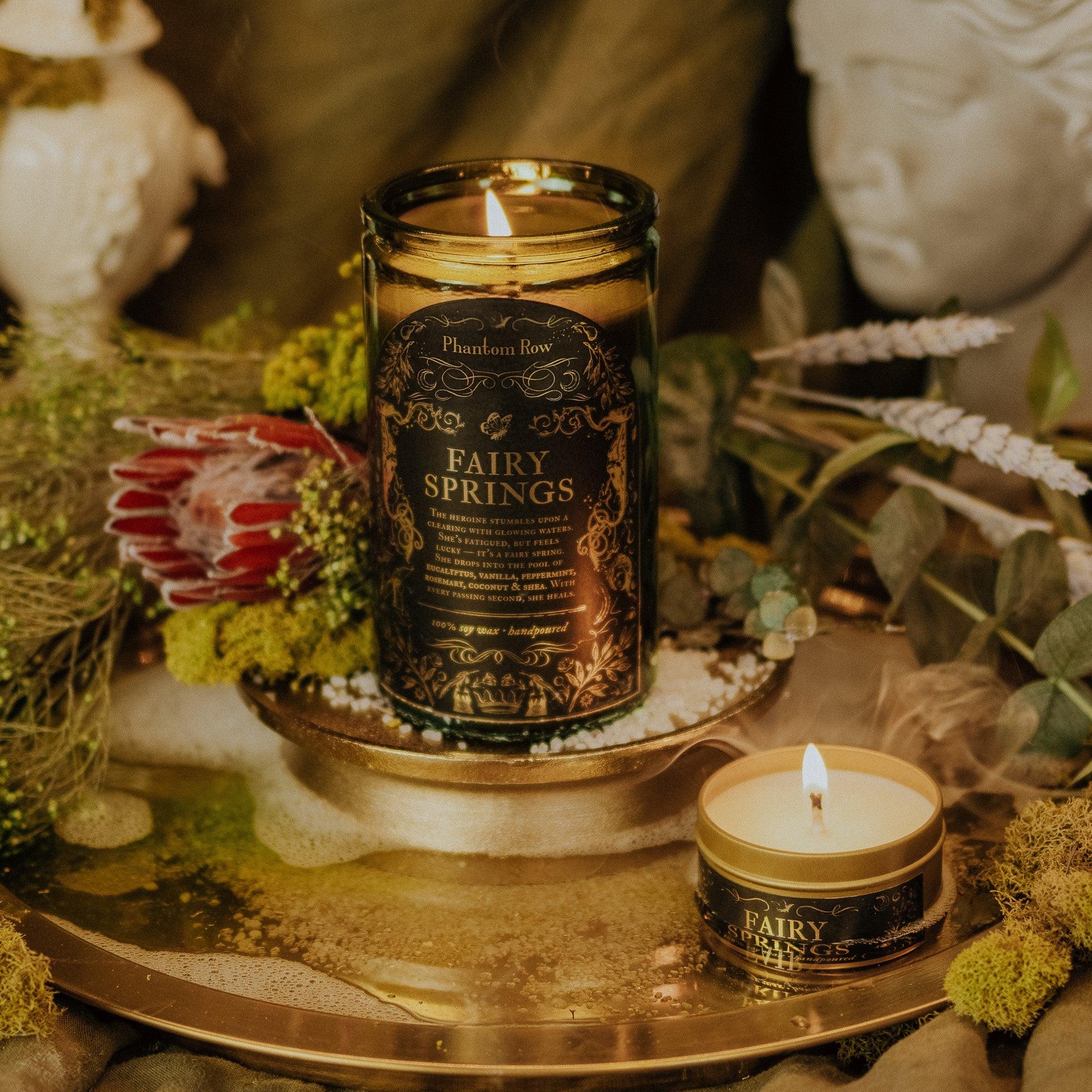 Phantom Row Fairy Springs Candle with whimsical fairy design, glowing wick, and intricate details in a cozy candle setting.