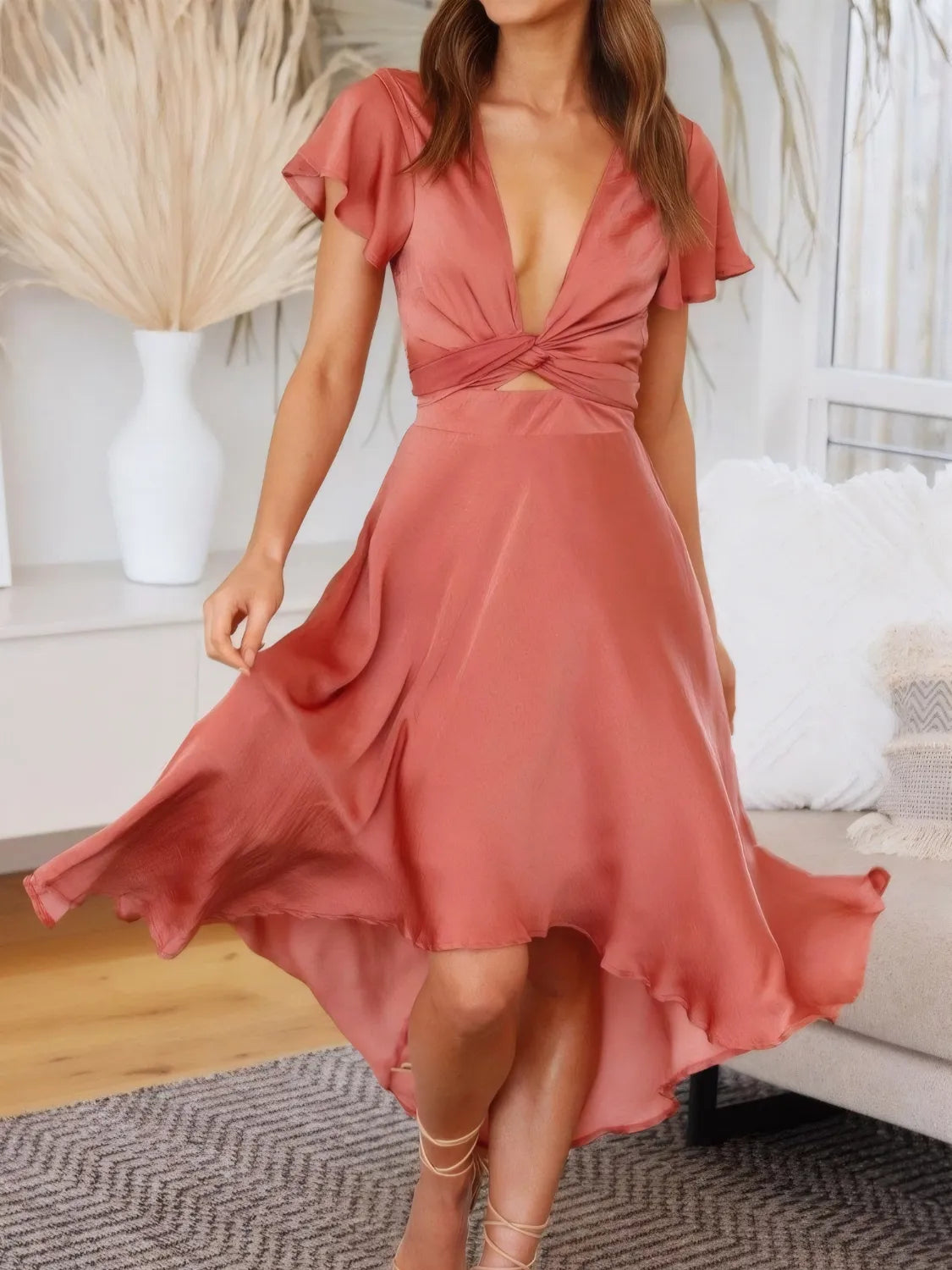 Coral Flutter Skies high-low dress with plunge neckline and crisscross back, worn by a model showing front view.